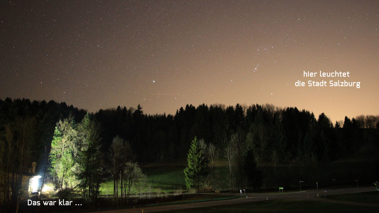 Lichtverschmutzung - Beleuchtung einer Werbetafel und die Stadt Salzburg