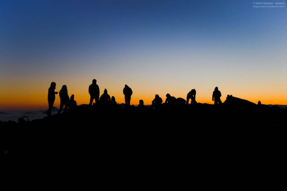 Menschen im Gegenlicht auf Gipfel