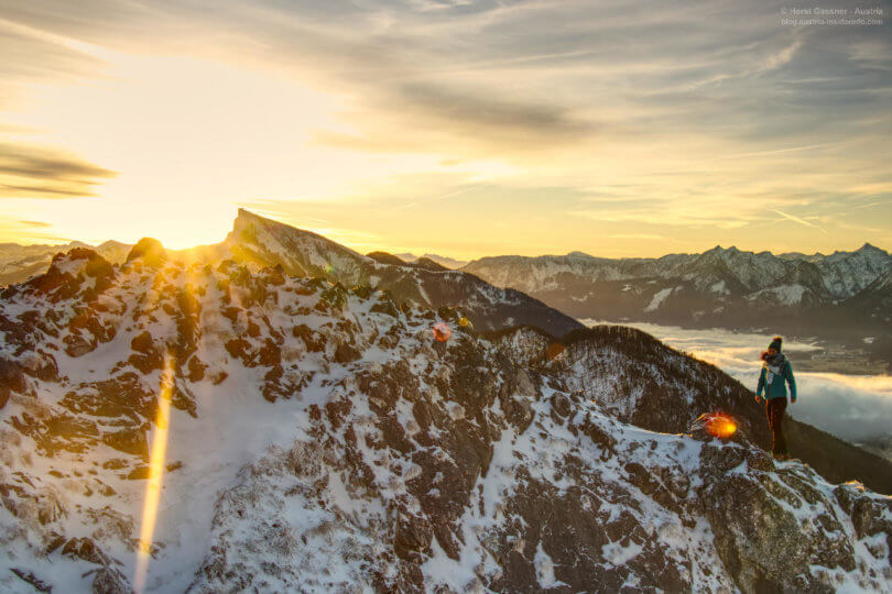 Sonnenaufgang über den Bergen mit junger Frau