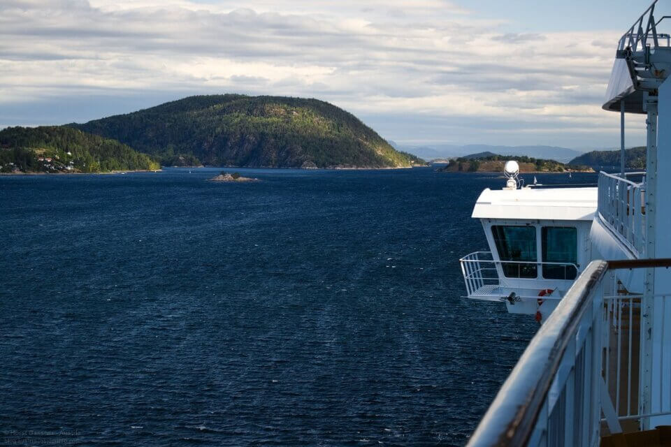Einfahrt in den Oslofjord. Dunkelblaues Meer, Hügel im Hintergrund.